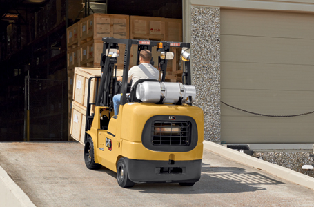 Operator Driving a Loaded CAT Forklift up a Ramp 