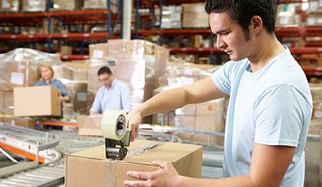 Workers in warehouse inspecting and taping boxed goods