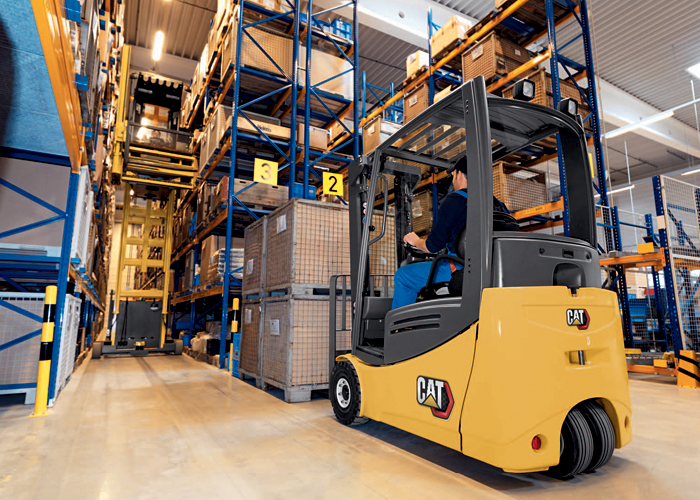 Worker backing Cat class i forklift out of moving truck