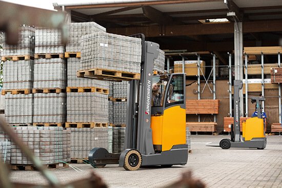 Operator Using a Jungheinrich Moving Mast Reach Truck to Move Material Outdoors