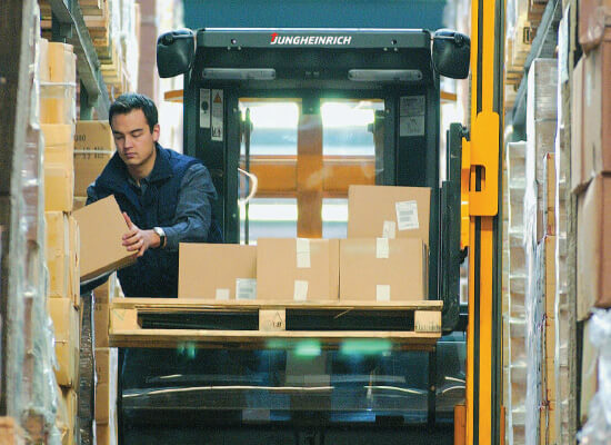 Operator Picking Material off a EKX 410 in a Warehouse Aisle