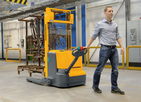 Straddle stacker being walked by operator