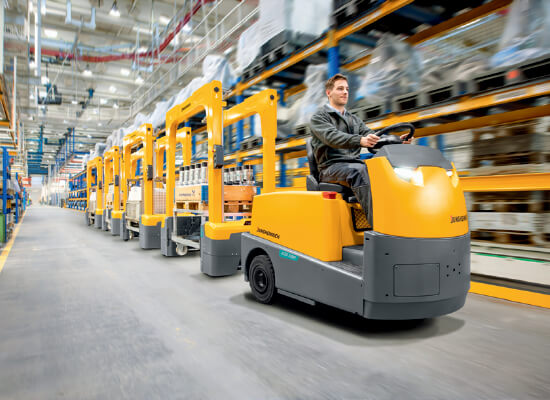 A Jungheinrich EZS Tow Tractor Driving through a Warehouse