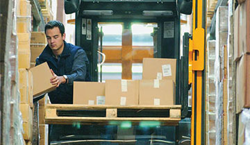 Worker loading boxes onto pallet of Jungheinrich high-rack turret truck