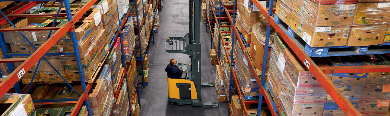 Worker using Jungheinrich order picker to reach high shelf