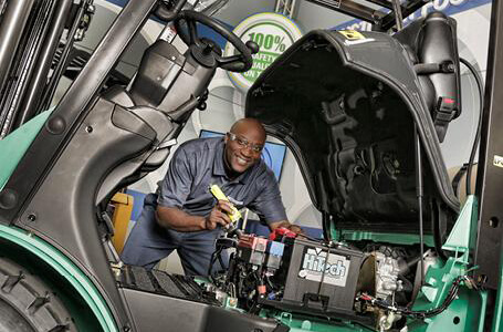 Man servicing Mit forklift engine