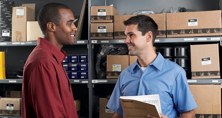 2 people talking over forklift paperwork