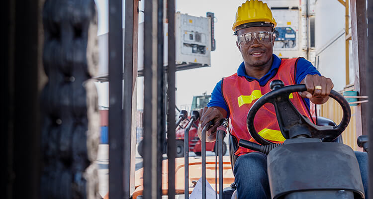 forklift operator driving lift truck toward camera