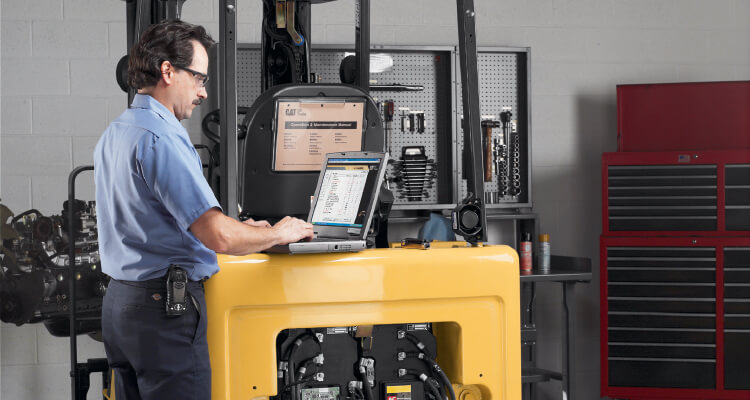 Man on laptop checking forklift