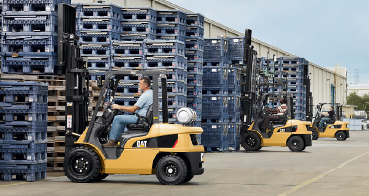 3 Cat IC lift trucks picking up pallets outside