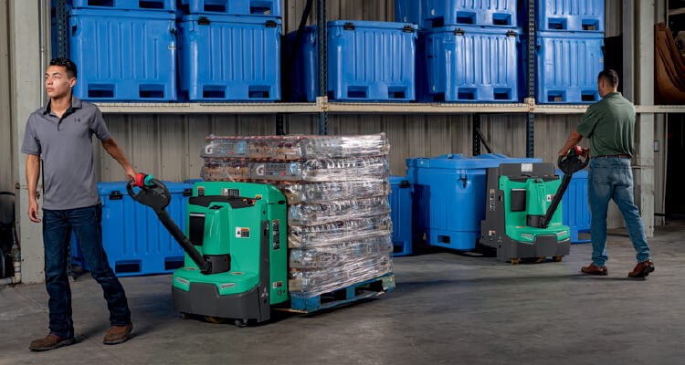 Worker moving pallet using walkie pallet truck for loadout