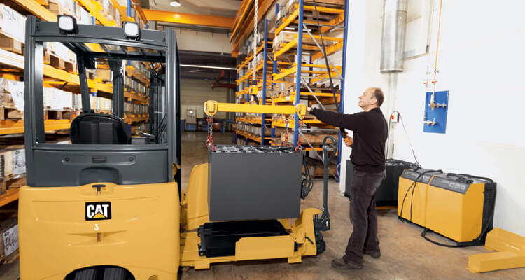 Worker Loading a Battery into a CAT Electric Forklift