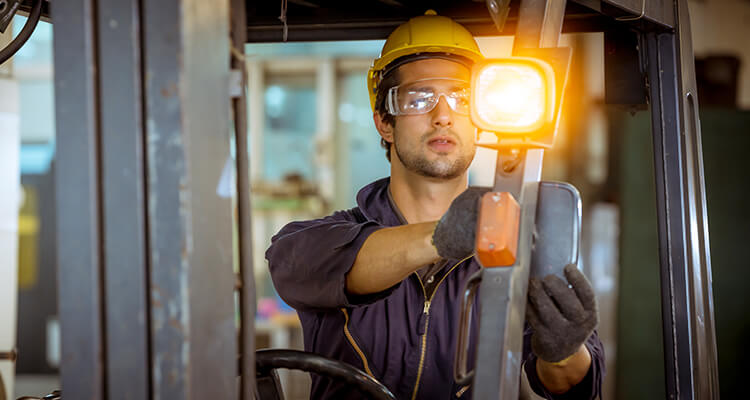 Man installing flashing amber light on forklift