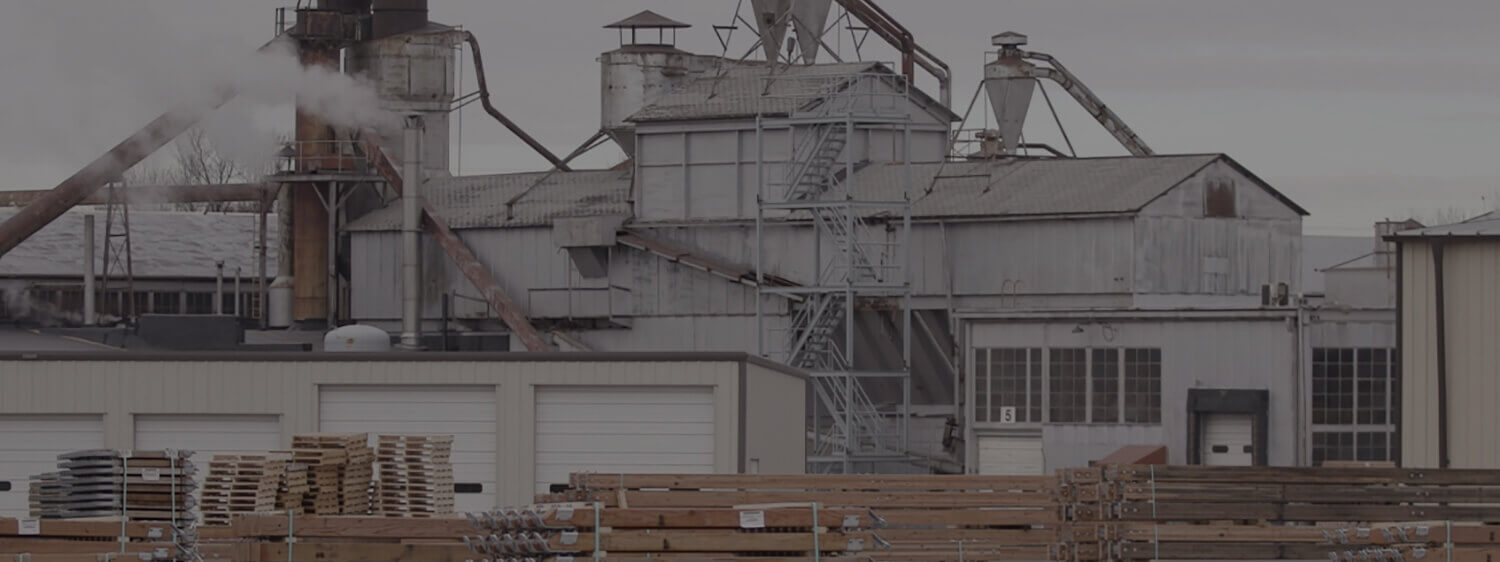 White and gray factory with stacks of materials and storage units in front