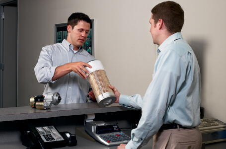 Two Men Discussing a Forklift Part