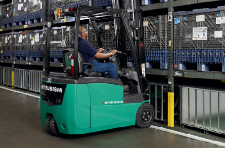 Forklift operator lifting storage container