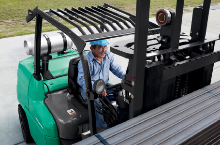 Man lifting steel rods using a Mitsubishi forklift truck