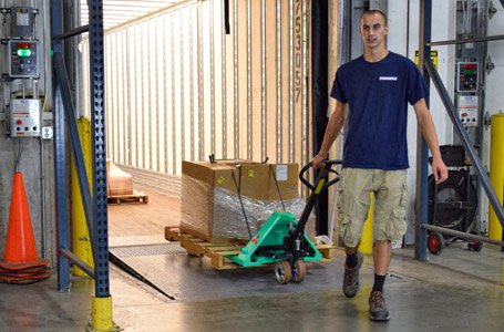 Operator pulling Mitsubishi hand pallet truck by handle