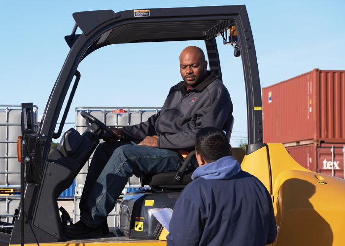 One Worker on a CAT Forklift Discussing with Another Worker