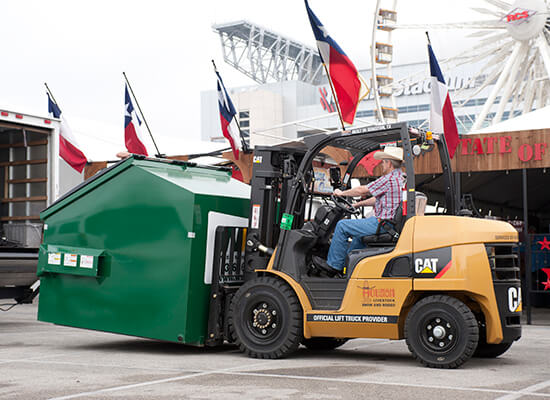 Man with Cowboy Hat Lifting a Recycling Bin with a CAT Forklift
