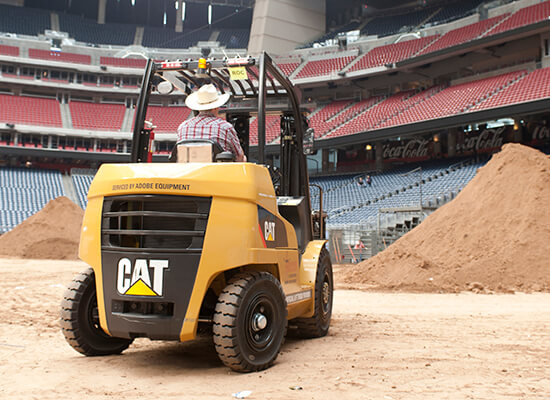 Man Driving a Cat Forklift in the Houston Rodeo Stadium