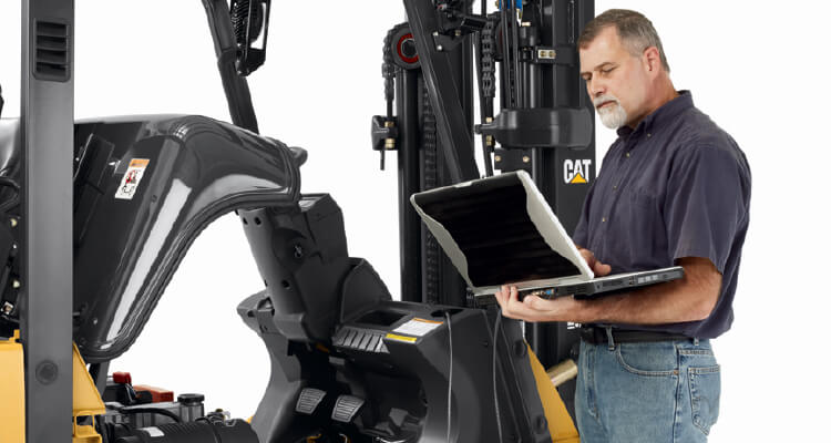Man looking at laptop connected to forklift